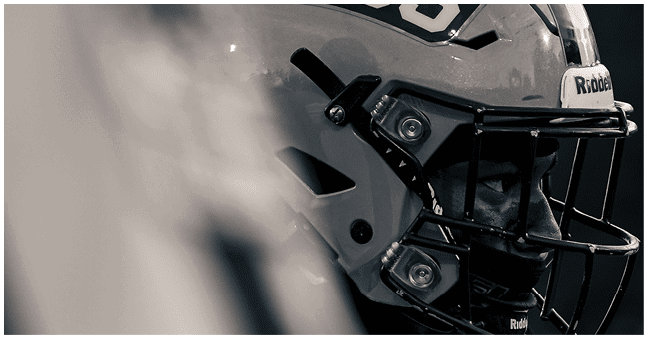 A close-up of a person wearing a football helmet with the letters RBS on the side. Description generated by AI