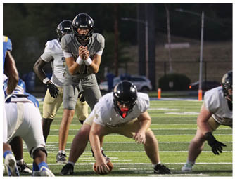 A group of football players on a field. Description generated by AI