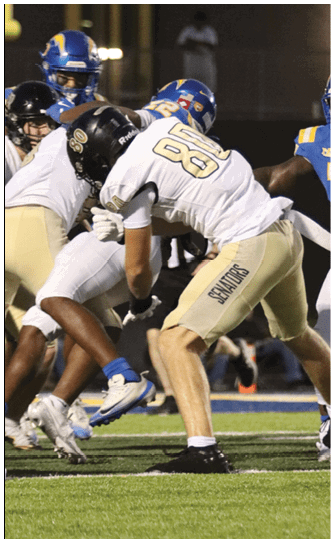 A football player catching a ball. Description generated by AI