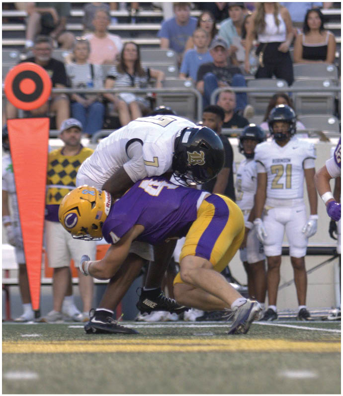 A group of football players wearing black and white uniforms. Description generated by AI