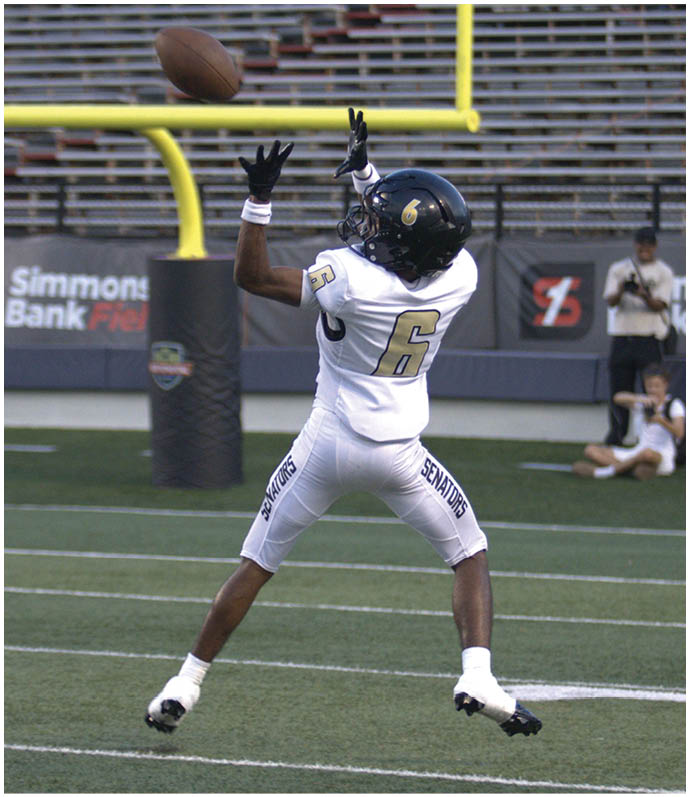A group of football players wearing black and white uniforms. Description generated by AI