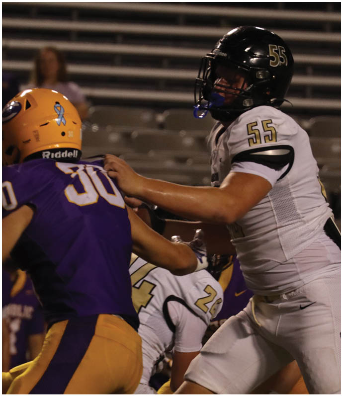A group of football players wearing black and white uniforms. Description generated by AI