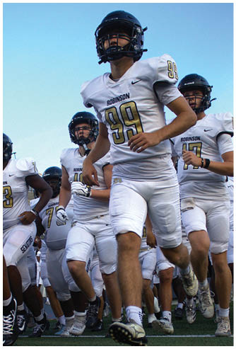 A football player running on the field. Description generated by AI