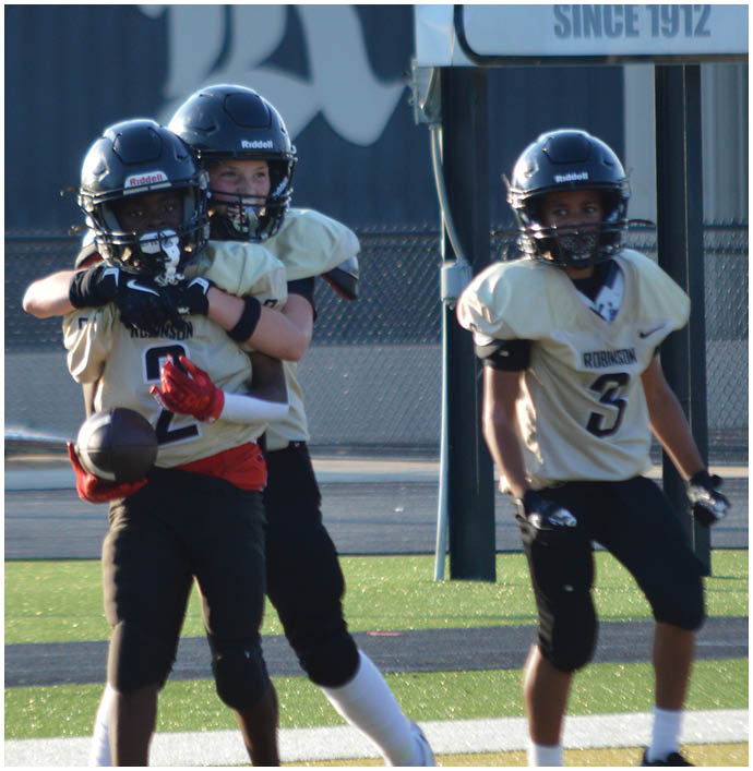 A group of football players wearing black and white uniforms. Description generated by AI