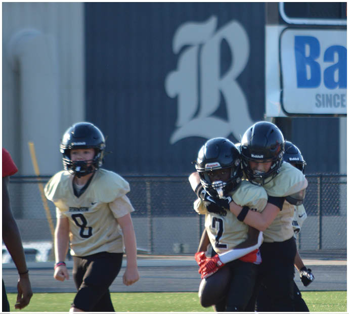 A group of football players wearing black and white uniforms. Description generated by AI