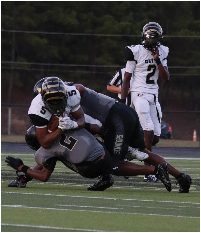 A group of football players wearing black and white uniforms. Description generated by AI