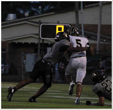 A group of football players huddled together on the field. Description generated by AI