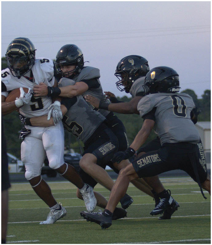 A group of football players wearing black and white uniforms. Description generated by AI