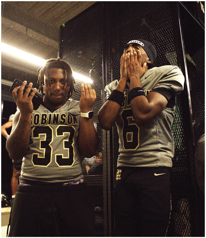 A group of football players wearing black and white uniforms. Description generated by AI