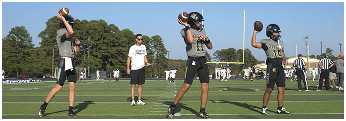 A group of football players on a field. Description generated by AI