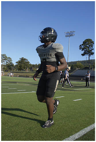 A football player running on the field. Description generated by AI