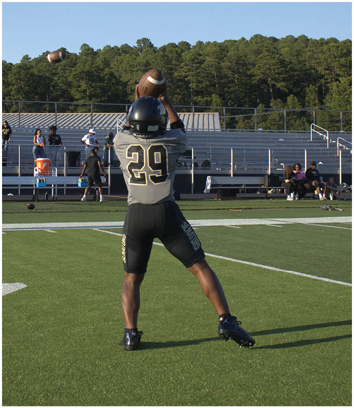 A group of football players wearing black and white uniforms. Description generated by AI