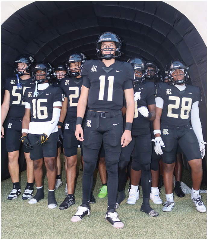 A group of football players wearing black and white uniforms. Description generated by AI