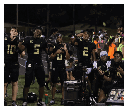 Two football players celebrating a touchdown with one player jumping in the air. AI generated content
