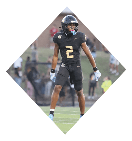 A football player wearing a black jersey with the number 3 kneels on the field. AI generated content