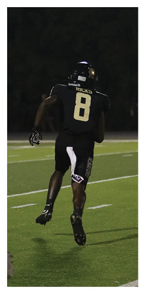 A man in a green shirt and black pants is preparing to throw a football. AI generated content