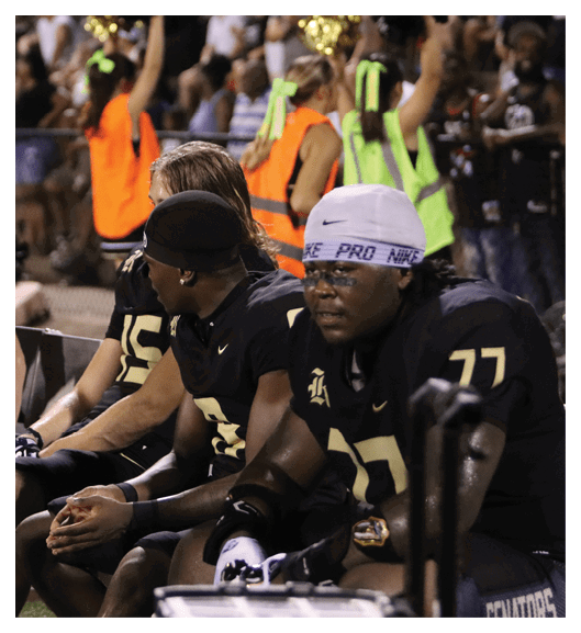 Two football players wearing Vista jerseys and holding hands. AI generated content