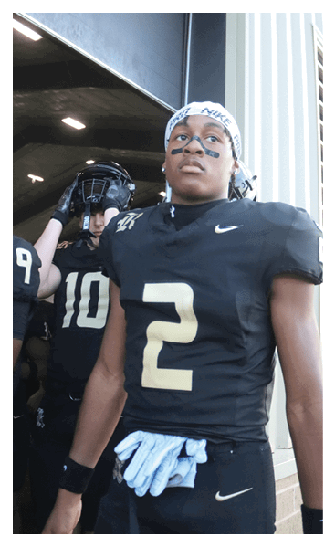 A football player wearing a black and white uniform with the number 10 on the back. AI generated content