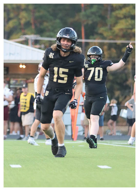 A football player wearing a helmet and white uniform is holding his helmet above his head. AI generated content