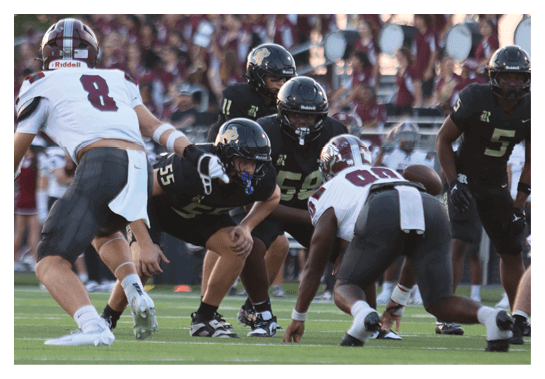 A group of people are kneeling on a field, possibly in a football game. AI generated content