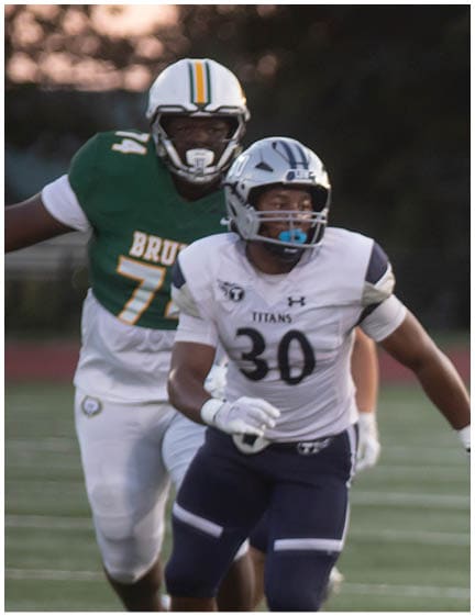 A football player wearing a blue and white uniform. Description generated by AI
