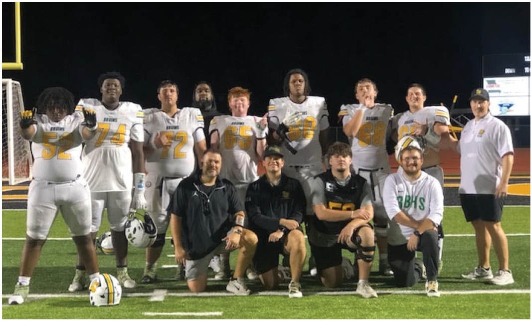 A group of football players wearing black and white uniforms. Description generated by AI