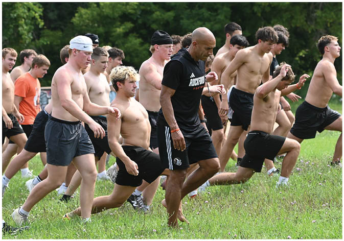 A group of football players wearing black and white uniforms. Description generated by AI