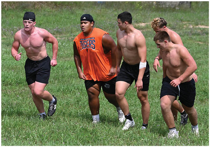 A group of football players wearing black and white uniforms. Description generated by AI