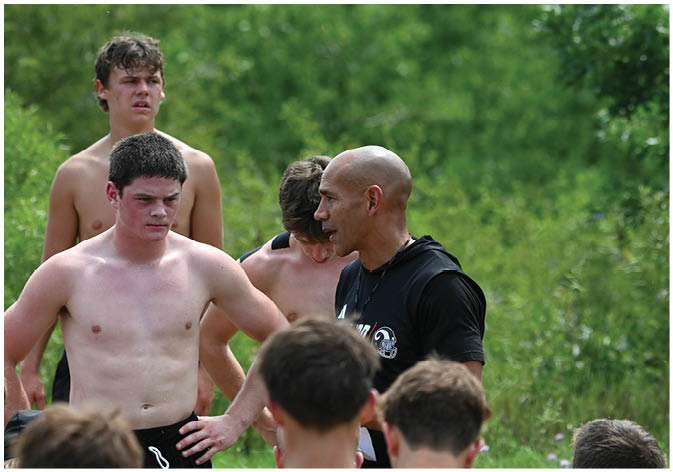 A group of football players wearing black and white uniforms. Description generated by AI