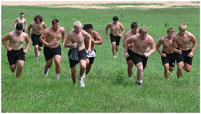 A group of football players on a field. Description generated by AI
