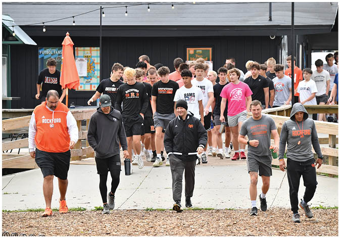 A group of football players wearing black and white uniforms. Description generated by AI