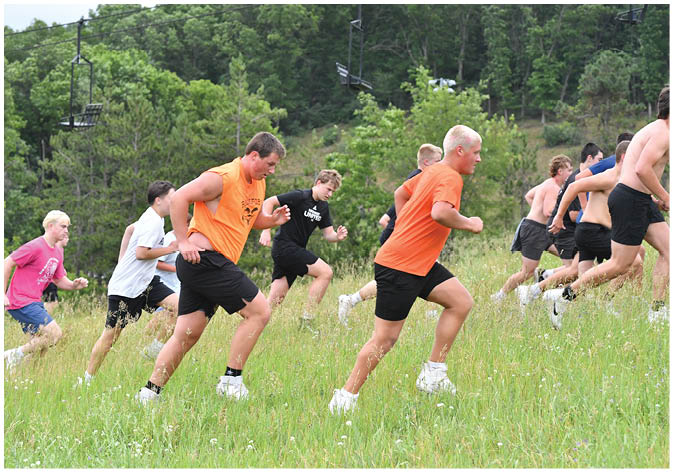 A group of football players wearing black and white uniforms. Description generated by AI