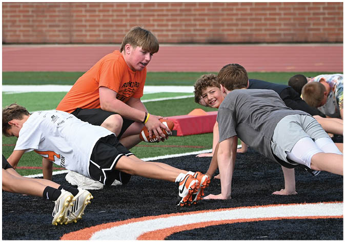 A group of football players wearing black and white uniforms. Description generated by AI