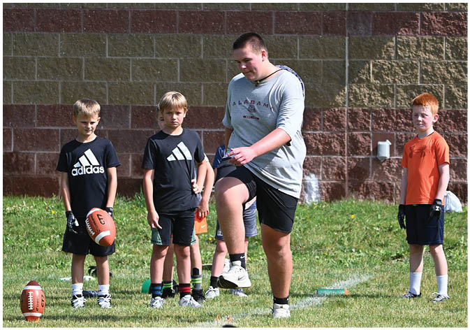 A group of football players wearing black and white uniforms. Description generated by AI