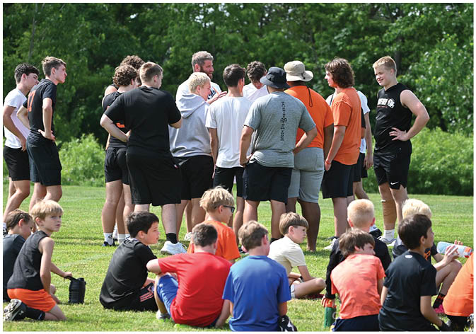 A group of football players wearing black and white uniforms. Description generated by AI