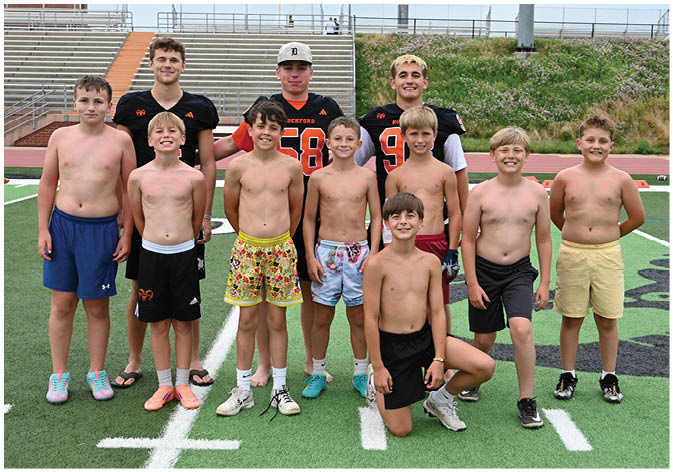 A group of football players wearing black and white uniforms. Description generated by AI