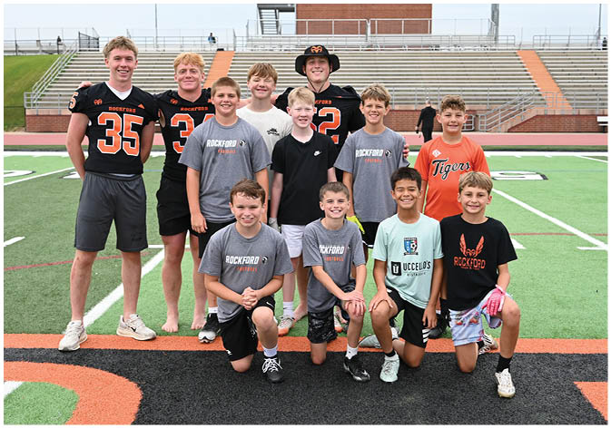 A group of football players wearing black and white uniforms. Description generated by AI