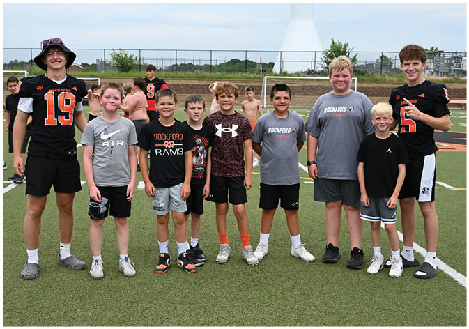 A group of football players wearing black and white uniforms. Description generated by AI