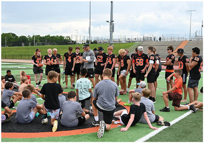 A group of football players wearing black and white uniforms. Description generated by AI