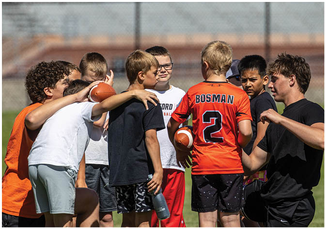 A group of football players wearing black and white uniforms. Description generated by AI
