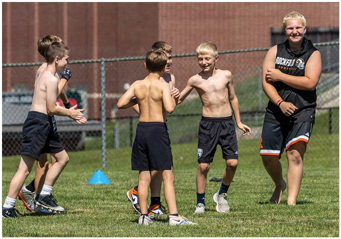 A group of football players wearing black and white uniforms. Description generated by AI