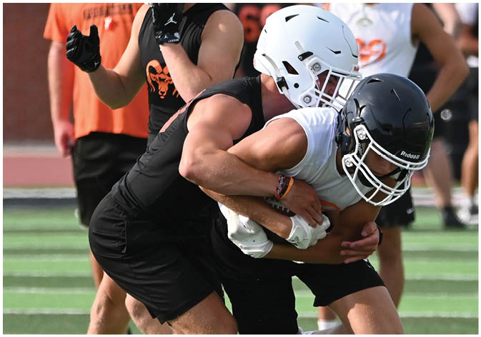 A group of football players wearing black and white uniforms. Description generated by AI