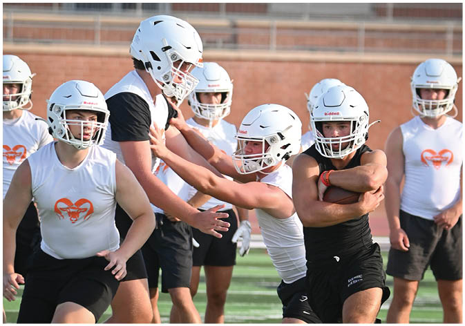 A group of football players wearing black and white uniforms. Description generated by AI