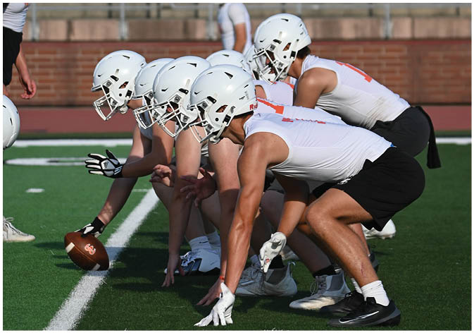 A group of football players wearing black and white uniforms. Description generated by AI