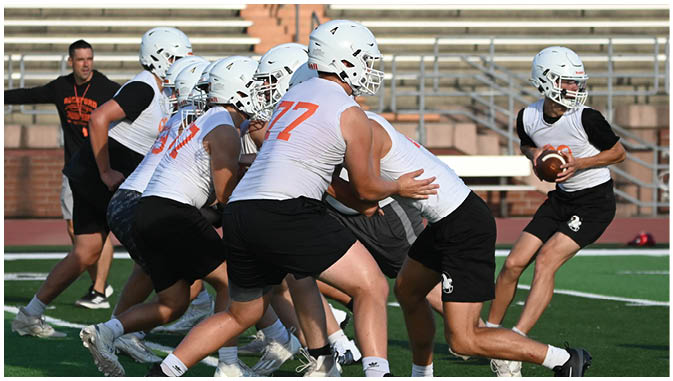 A group of football players on a field. Description generated by AI