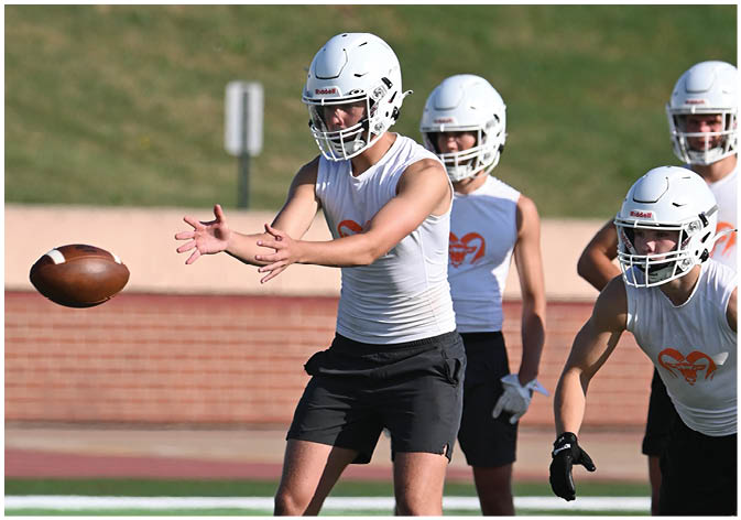 A group of football players wearing black and white uniforms. Description generated by AI