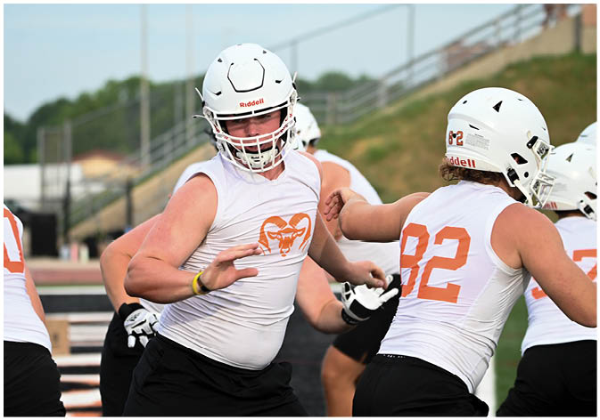 A group of football players wearing black and white uniforms. Description generated by AI