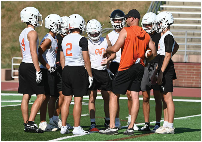 A group of football players wearing black and white uniforms. Description generated by AI