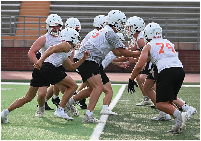 A group of football players wearing black and white uniforms. Description generated by AI