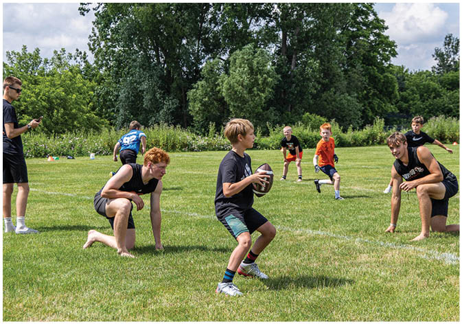 A group of football players wearing black and white uniforms. Description generated by AI